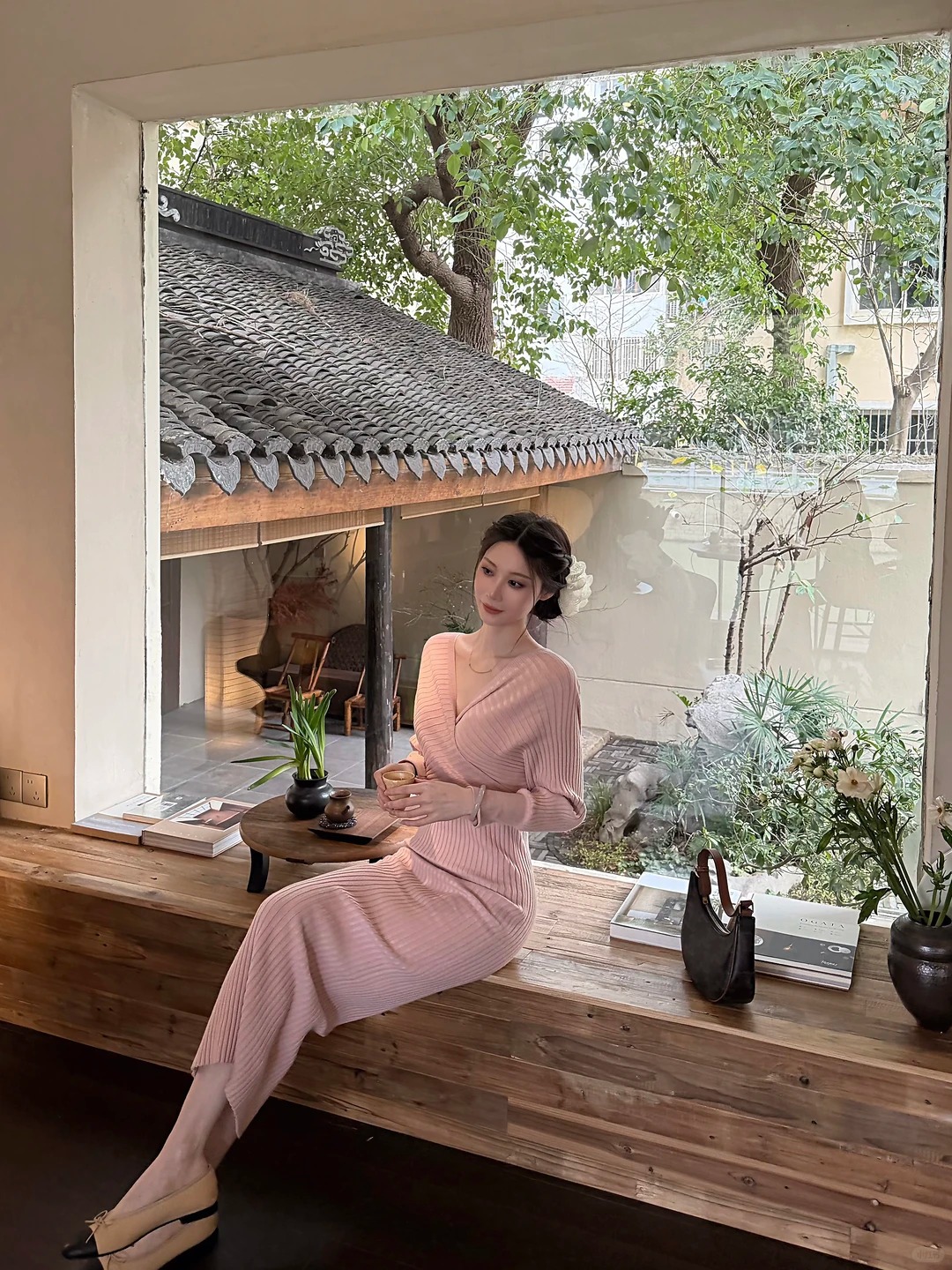 穿粉色衣裙的女性坐在窗边